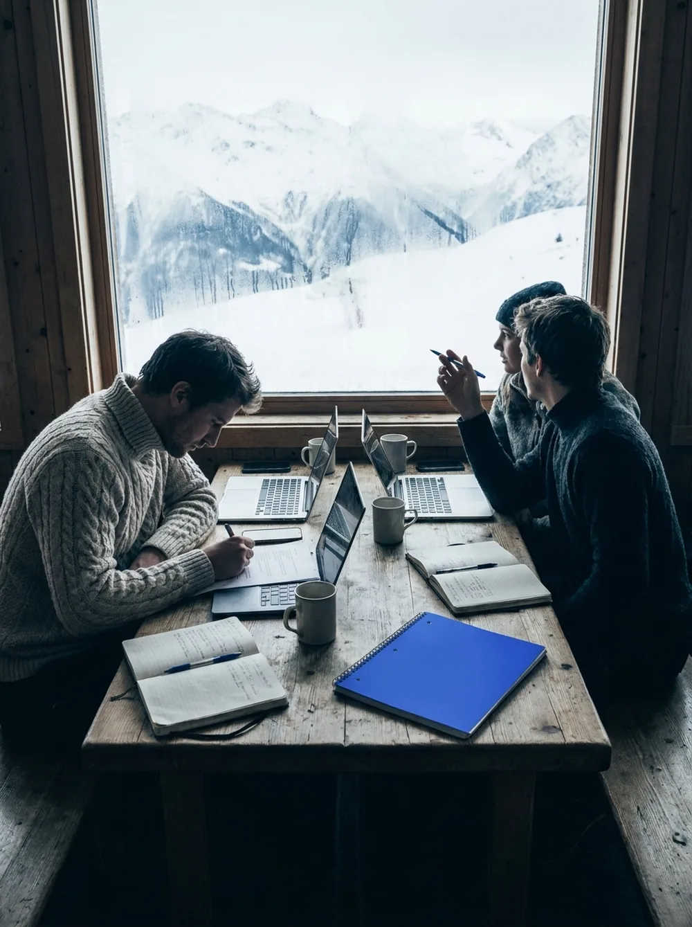 The Ascent strategy team working at a table by a window with mountains outside