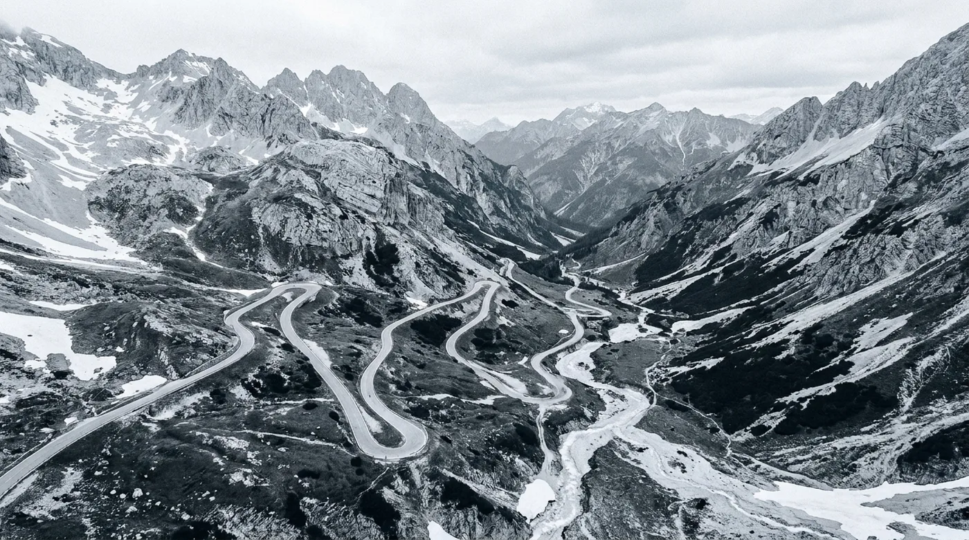 A mountain pass road winding up through an alpine valley